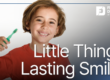 child holding toothbrush and smiling